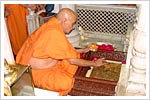 Swamishri reverentially touches the charanarvind