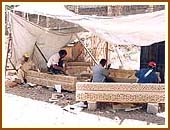 Craftsmen from India are seen carving the sandstone slabs.