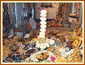 Swamishri joins in the singing of the thals before the Annakut - mountain of food - devoutly decorated and offered to God at the beginning of each year as a form of thanksgiving.