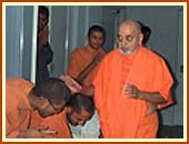 Swamishri emerges from 
his room and warmly greets the sadhus and devotees with folded hands and affectionate Jai Swaminarayans