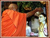 Swamishri performing Abhishek of the Murtis