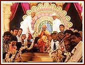 The leading devotees of Valsad and Tithal offer a giant garland to Swamishri