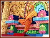 Swamishri seated on a resplendent stage, serenely chanting the holy name of Swaminarayan