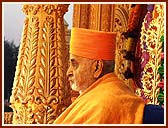 Swamishri seated on a resplendent stage, serenely chanting the holy name of Swaminarayan