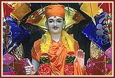 With a backdrop of kites, Shri Ghanshyam Maharaj is donned in saffron clothes of a sadhu and begging bags (jolis) in both hands