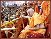 In a joyous mood, Swamishri profusely showers the holy water on the devotees and sadhus. About 43,000 devotees had assembled for the Fuldol festival