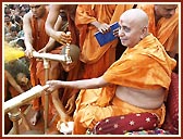 In a joyous mood, Swamishri profusely showers the holy water on the devotees and sadhus. About 43,000 devotees had assembled for the Fuldol festival