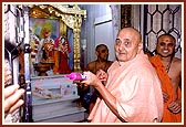 Sprinkling colored water on devotees in the mandir