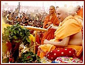 In a joyous mood, Swamishri profusely showers the holy water on the devotees and sadhus. About 43,000 devotees had assembled for the Fuldol festival