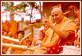 In a joyous mood, Swamishri profusely showers the holy water on the devotees and sadhus. About 43,000 devotees had assembled for the Fuldol festival