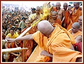 In a joyous mood, Swamishri profusely showers the holy water on the devotees and sadhus. About 43,000 devotees had assembled for the Fuldol festival