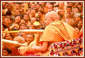 In a joyous mood, Swamishri profusely showers the holy water on the devotees and sadhus. About 43,000 devotees had assembled for the Fuldol festival