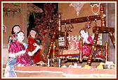 Depiction of  Bhaktimata gently rocking the new born Ghanshyam
