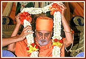 Honored with a garland of fragrant flowers during the evening assembly