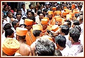 Swamishri on his way out, managing through the wall of devotees and local residents