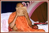 Swamishri devoutedly touches the chadar, to his eyes and head, that Shastriji Mahraj had covered on him as a mark of his appointment as president