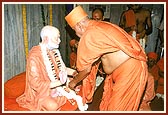 Swamishri places a garland and a kanthi on the murtis of Shastriji Maharaj and Yogiji Maharaj
