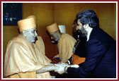 Mr. Bawa Jain, General Secretary of the Summit, greeting Swamishri after his address 