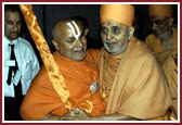 Swamishri being happily embraced by a respected Hindu religious leader for furthering the cause of Hinduism