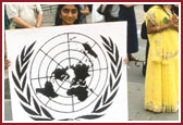 A BAPS volunteer welcomes delegates with the UN logo