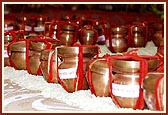 A hundred little pots of holy river water and soil in Swamishri's puja to be placed in the foundation pit