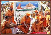 Doing pujan of the shlas (stones) symbolizing the gods of earth with rice grains, kumkum and flowers