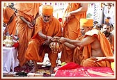 Swamishri places the Nidhikumbh in the center of the foundation pit 