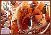 Swamishri places the Nidhikumbh in the center of the foundation pit 