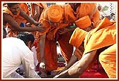 Swamishri places the Nidhikumbh in the center of the foundation pit 