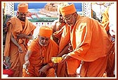 Swamishri pours cement into the pit