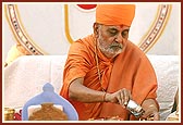 Doing pujan of the shlas (stones) symbolizing the gods of earth with rice grains, kumkum and flowers