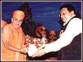 Hemraj Shah, president of the Brihad Gujarato Samaj, welcomes Swamishri with a bouquet of Flowers