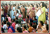 Women offer their respects from afar