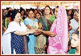 One of the donor representatives presents an auspicious pot to one of the home owners