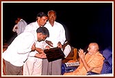 As part of the dedication ceremony, Swamishri offers a plaque to leading members of each village school