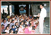 A teacher conducting a class in tin-tent city school