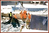 Volunteers and sadhus erecting a tent... 