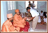 Sadhus distribute educational materials to students