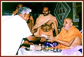 Swamishri presents the foundation bricks to leaders of the villages