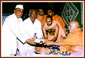 Swamishri presents the foundation bricks to leaders of the villages