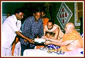 Swamishri presents the foundation bricks to leaders of the villages