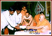 Swamishri presents the foundation bricks to leaders of the villages
