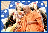 A child places his donation in Swamishri's joli