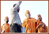The site engineer gives details of the construction crane to Swamishri