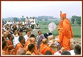 Swamishri blesses the devotees and sadhus by showering rice grains