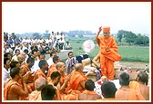 Swamishri blesses the devotees and sadhus by showering rice grains