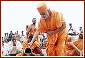 Swamishri pours cement to establish the first stone