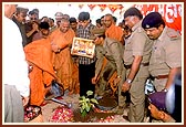 Swamishri plants a tree and sprinkles water