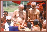 Swamishri bathes Shri Harikrishna Maharaj with the holy waters of Mansarovar on a platform besides the main boat-stage