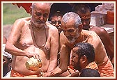 Swamishri bathes Shri Harikrishna Maharaj in the holy waters of Mansarovar on a platform besides the main boat-stage